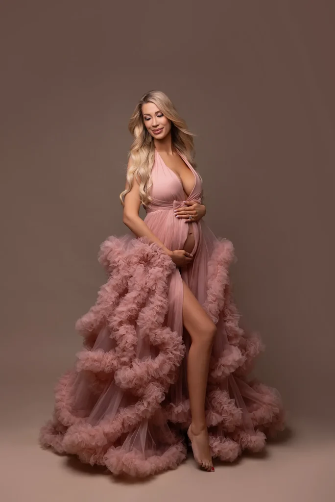 Zeigt ein Babybauchshooting Bild mit Tüllkleid in rosa in der Nähe von Mannheim