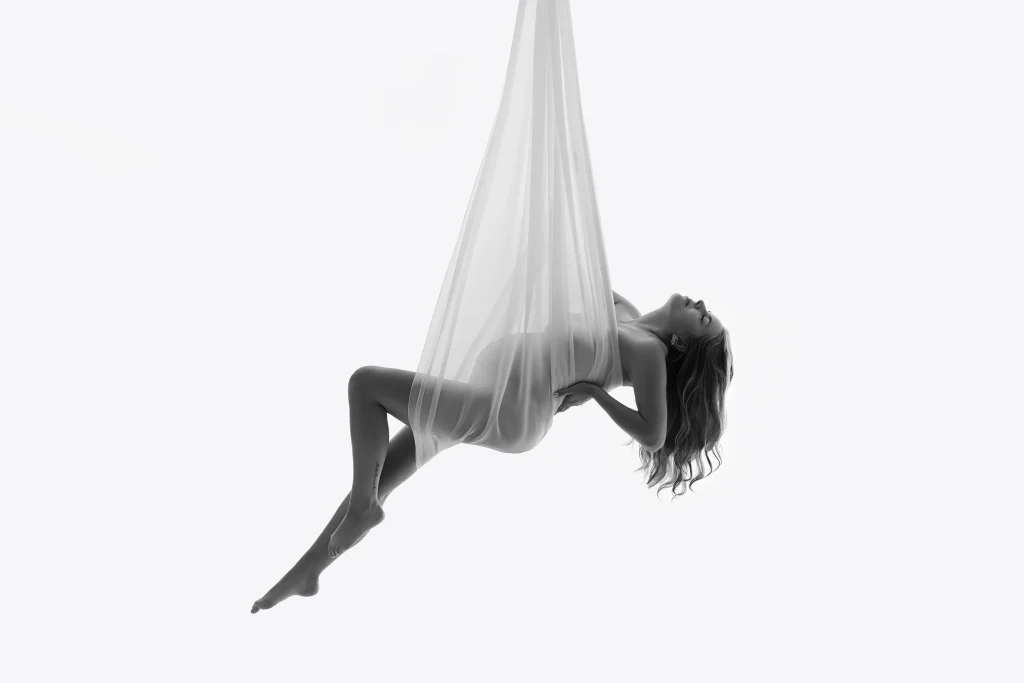 Zeigt eine schwangere Frau hängend in einem Tuch während eines Babybauchshootings in der Nähe von Frankfurt